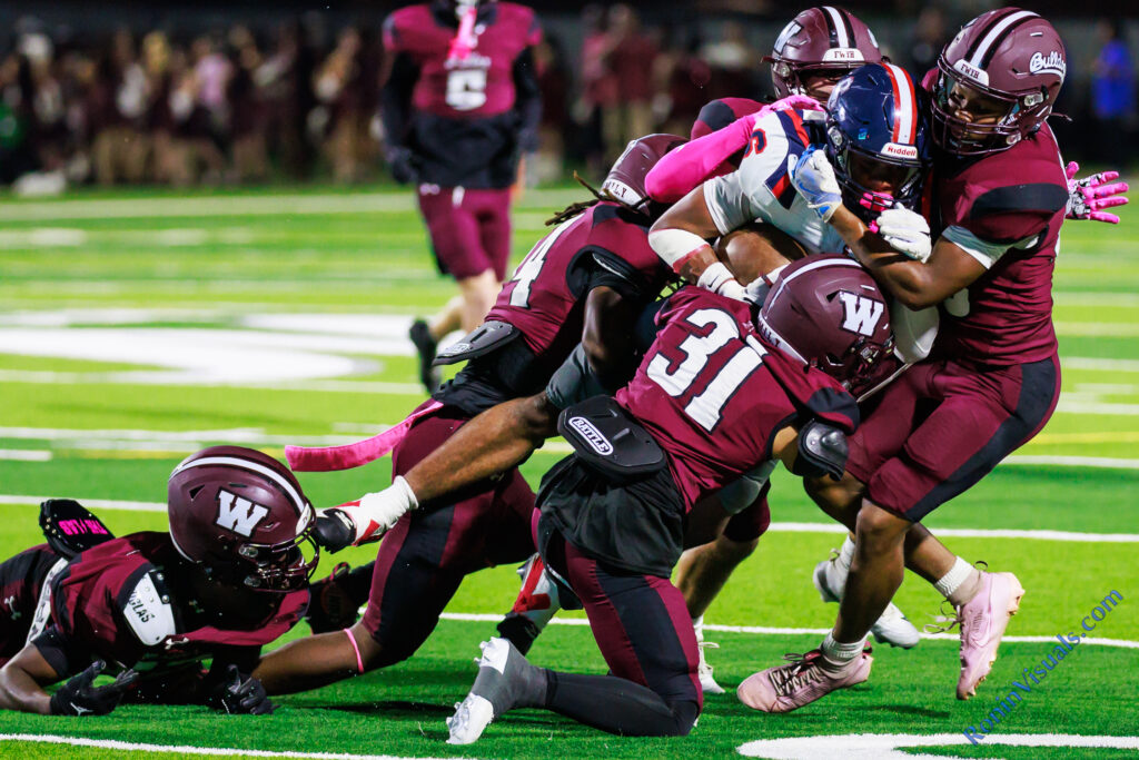 Bulldog defenders swarm tackle a Cy Springs ball carrier. The Waller Bulldogs defeat Cy Springs’ Panthers, 73-48, at Daikin Stadium in Waller, Texas, on Friday, Oct. 9, 2026. (Photo by Creighton Holub, © 2026 Ronin Visuals, all rights reserved.)